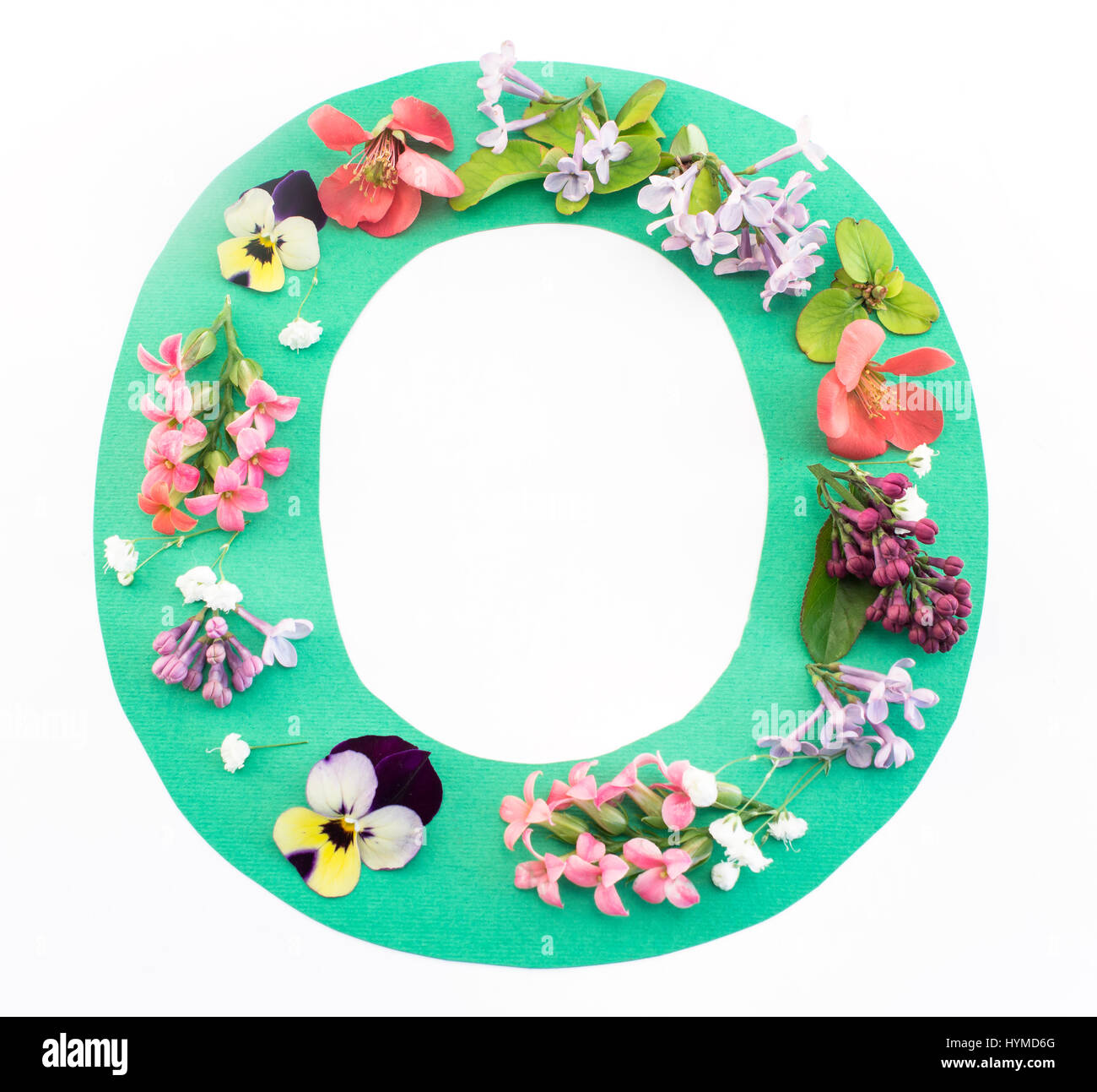 Buchstabe O gemacht von Frühlingsblumen und Papier auf weißem Hintergrund. Stockfoto