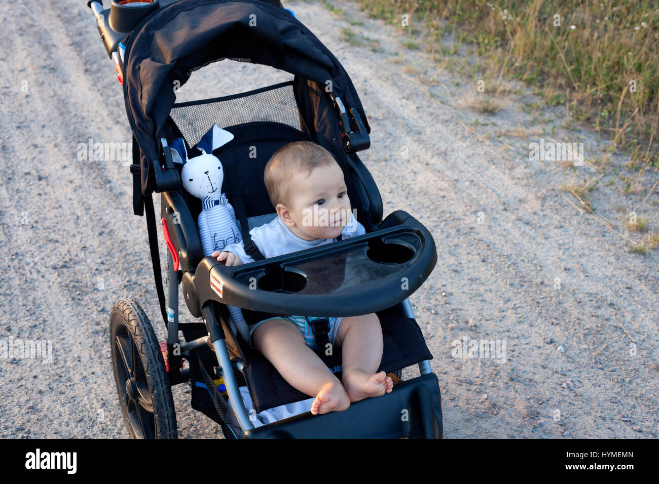 Alarmieren Sie barfuß Säugling Baby eine Fahrt in seinem Kinderwagen. Polnische Baby 7 Monate alt. Zawady Zentralpolen Europa Stockfoto