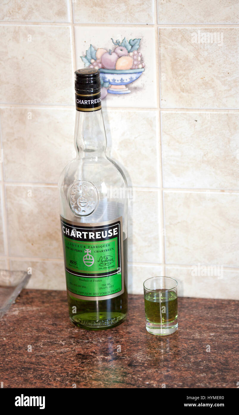 Eine Flasche Kräuterlikör Chartreuse grün und ein Schnapsglas sitzen auf der Küche Zähler warten nur darauf, getrunken werden. Zawady Zentralpolen Europa Stockfoto