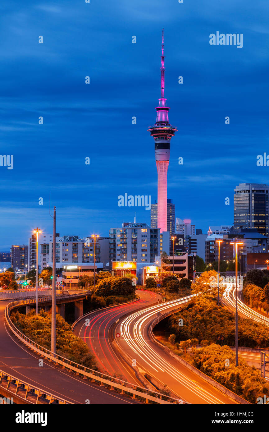 Auckland bei Dämmerung, mit Auto-Trails auf Autobahn beleuchtet. Stockfoto