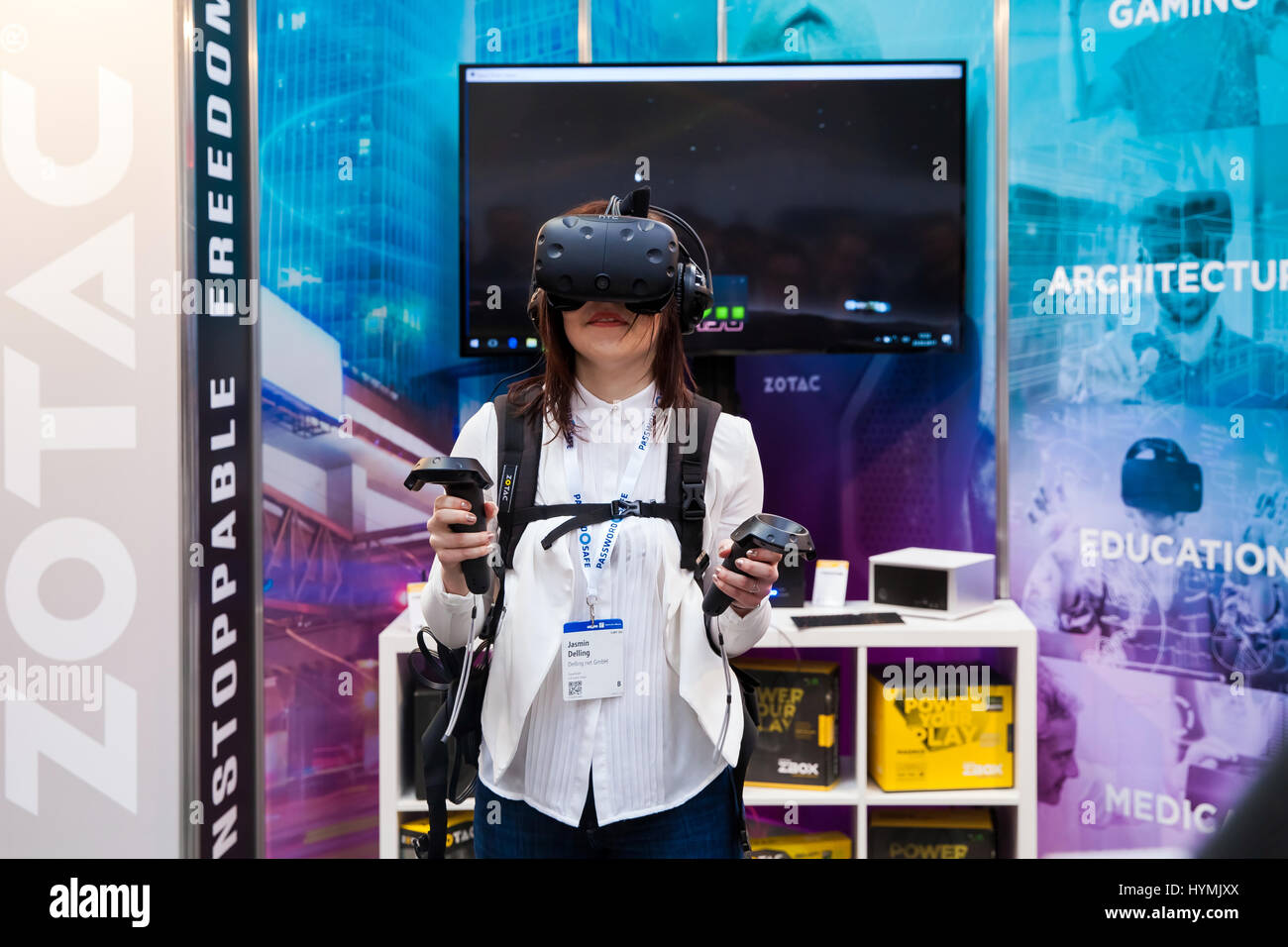 Mädchen spielen Videospiel in virtual-Reality-Kopfhörer und Handheld-Controller entwickelt von HTC Vive auf Messe Cebit 2017 in Hannover Messe, Deutschland Stockfoto