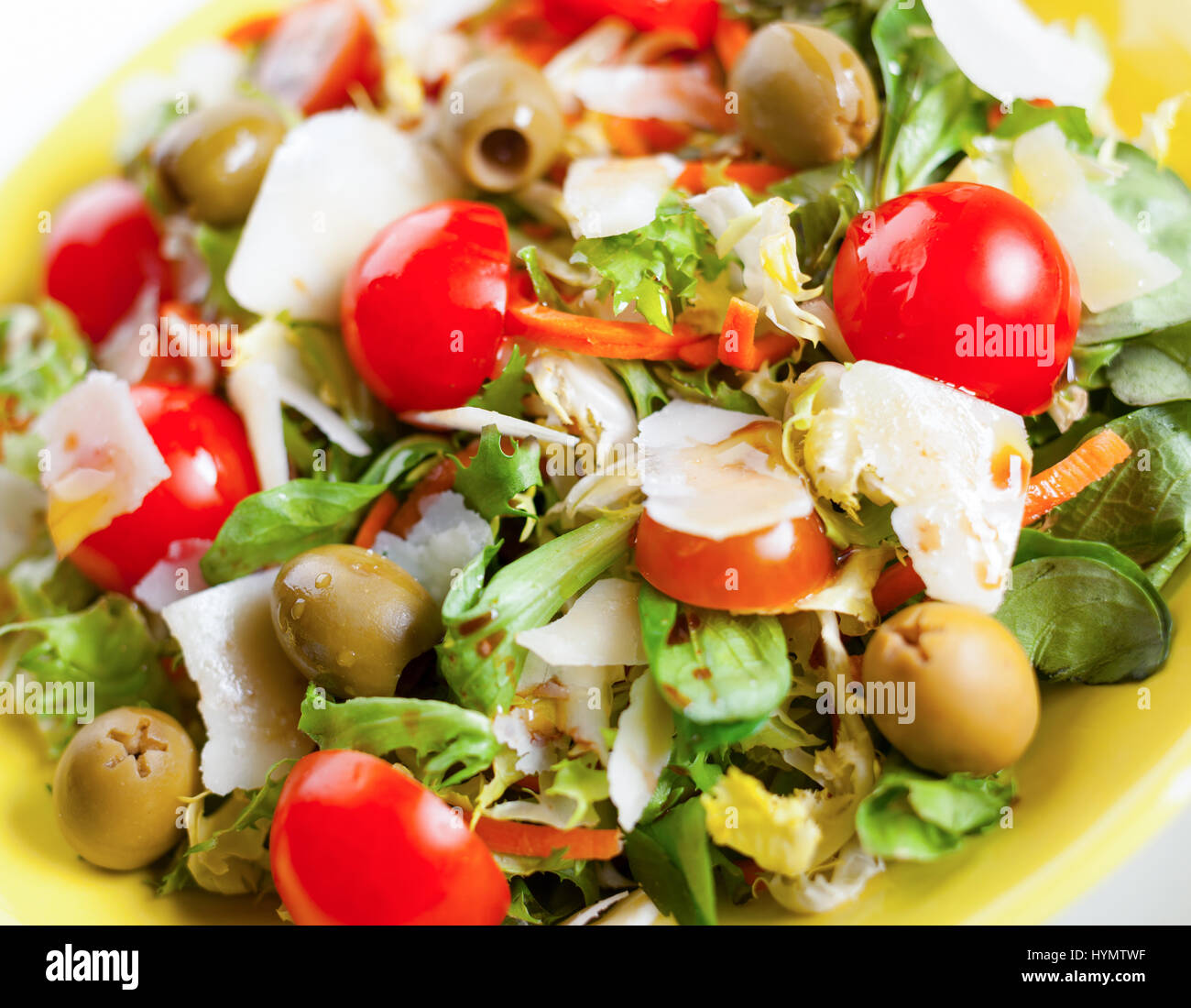 Gemischter Salat mit Oliven, Käse und Tomaten auf schwarzem Schiefer. Stockfoto