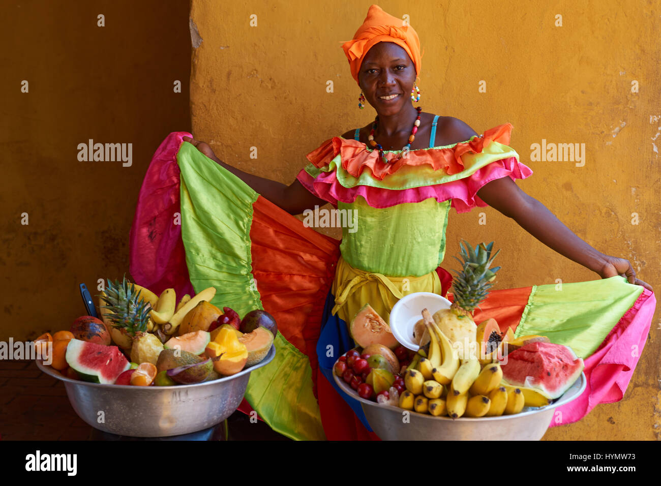 Frau in Tracht mit Obst in der ummauerten Altstadt von Cartagena de Indias in Kolumbien Stockfoto
