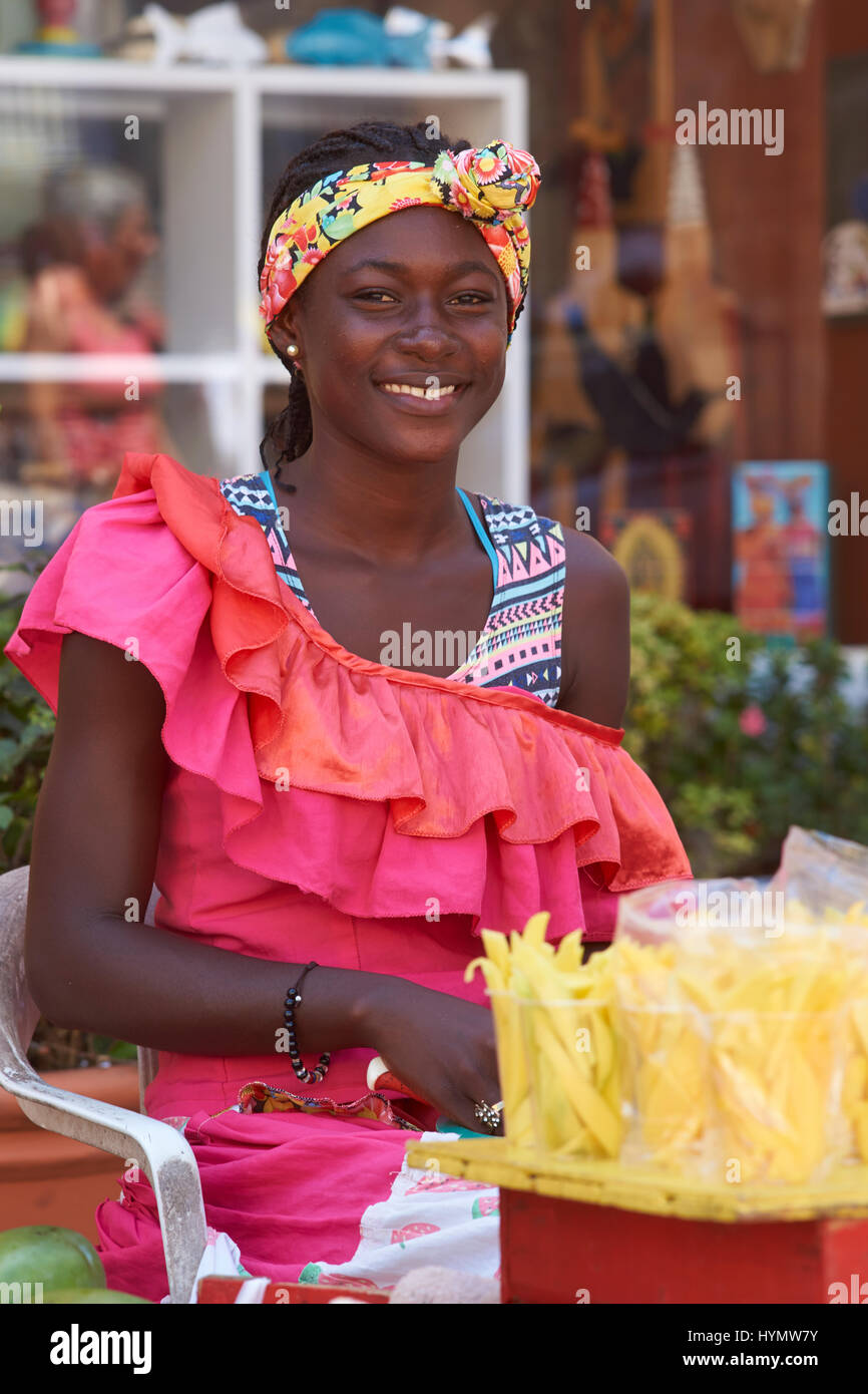 Frau in traditioneller Kleidung Verkauf von Obst in der ummauerten Altstadt von Cartagena de Indias in Kolumbien. Stockfoto