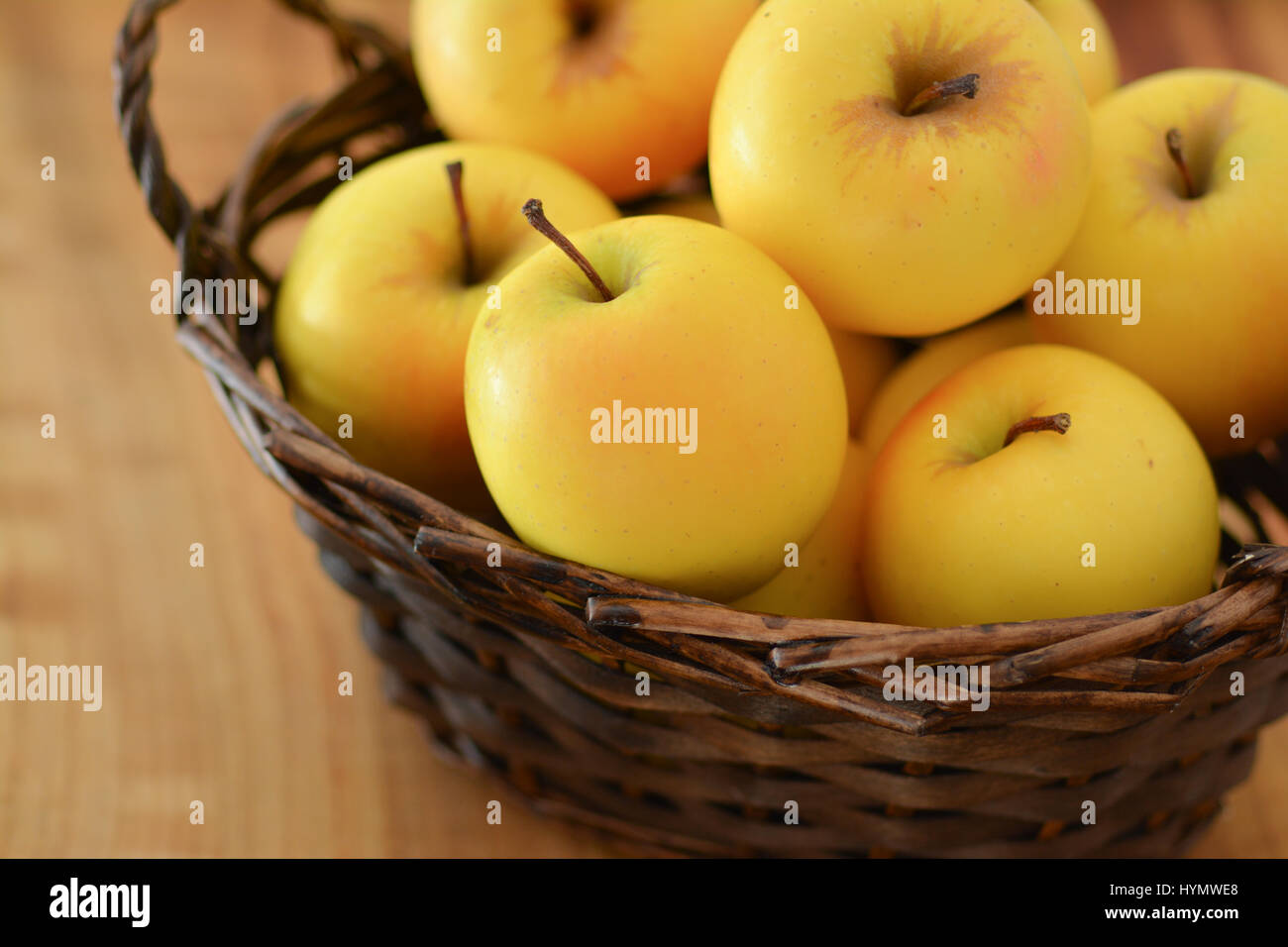 Nahaufnahme eines Korbs von goldenen Äpfeln Stockfoto