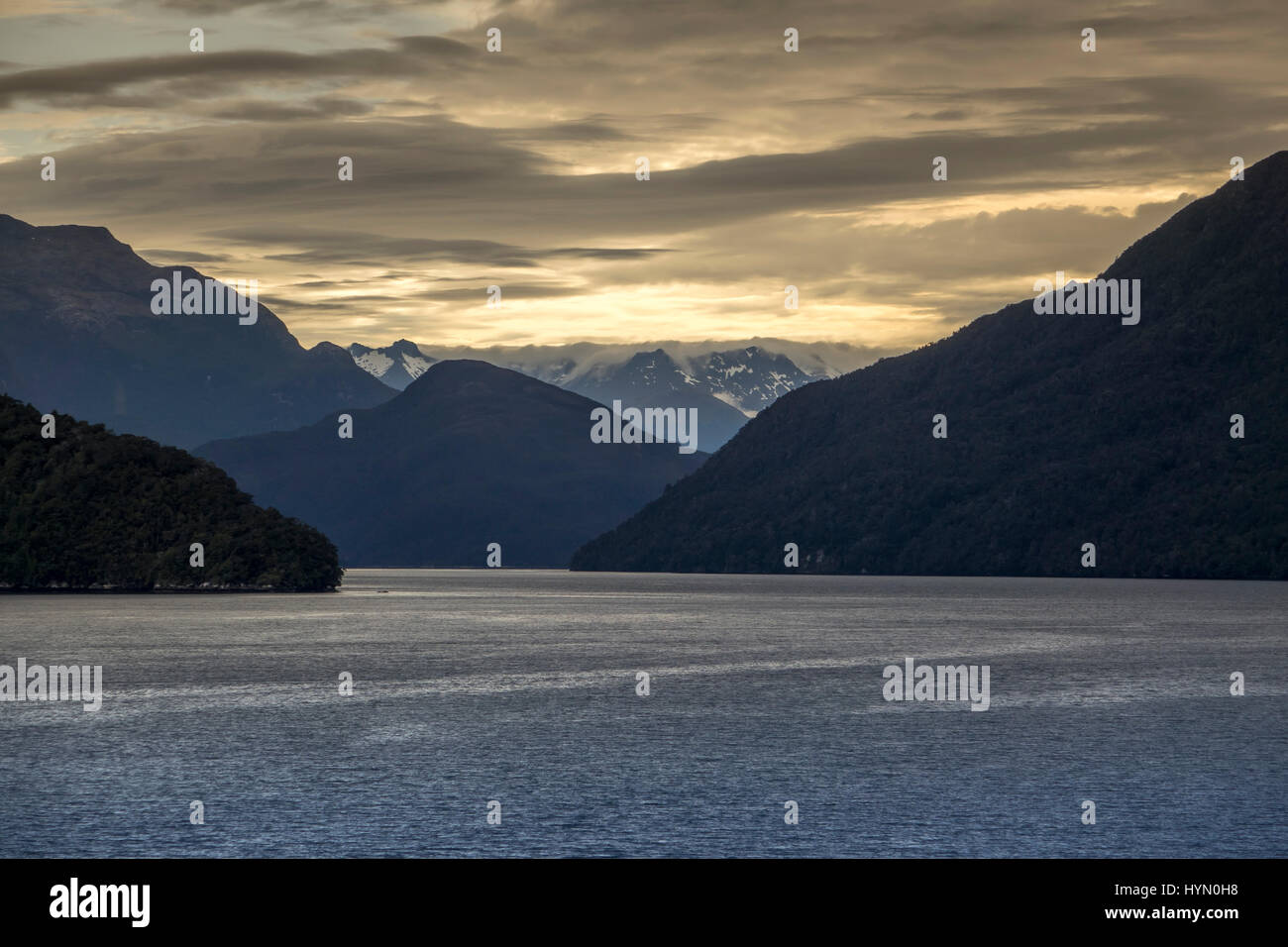 Sonne begrenzt Anstieg zweifelhaft Sound A Fjord In Fiordland South Island Neuseeland imposante Berge mit Schnee Gipfel Stockfoto