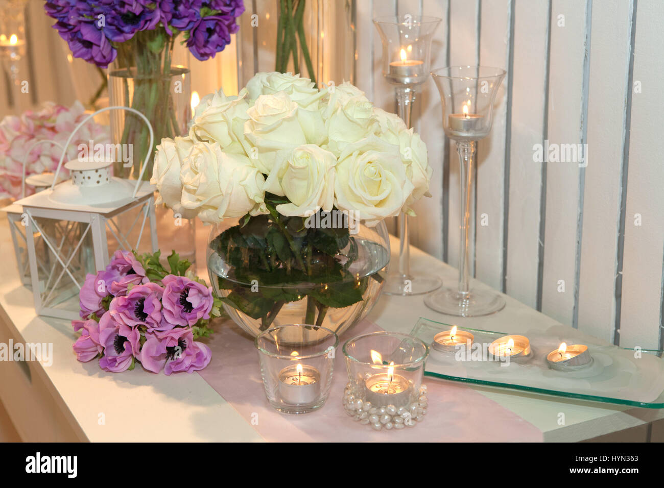 Tabelle mit weißen Rosen und Kerzen dekoriert Stockfoto