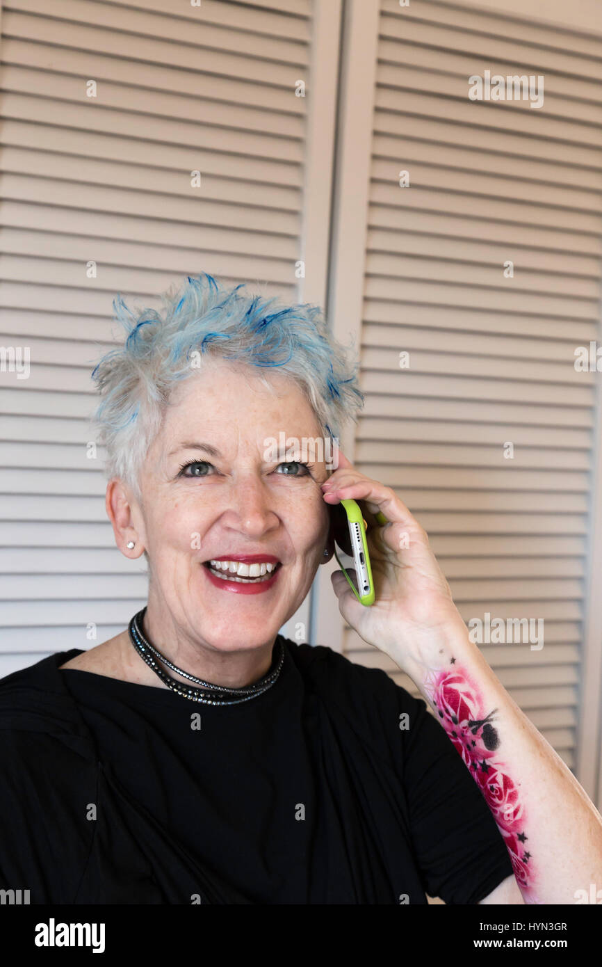 Optimistischen Senior Frau mit Tattoos und blaue Haare Highlights, USA Stockfoto