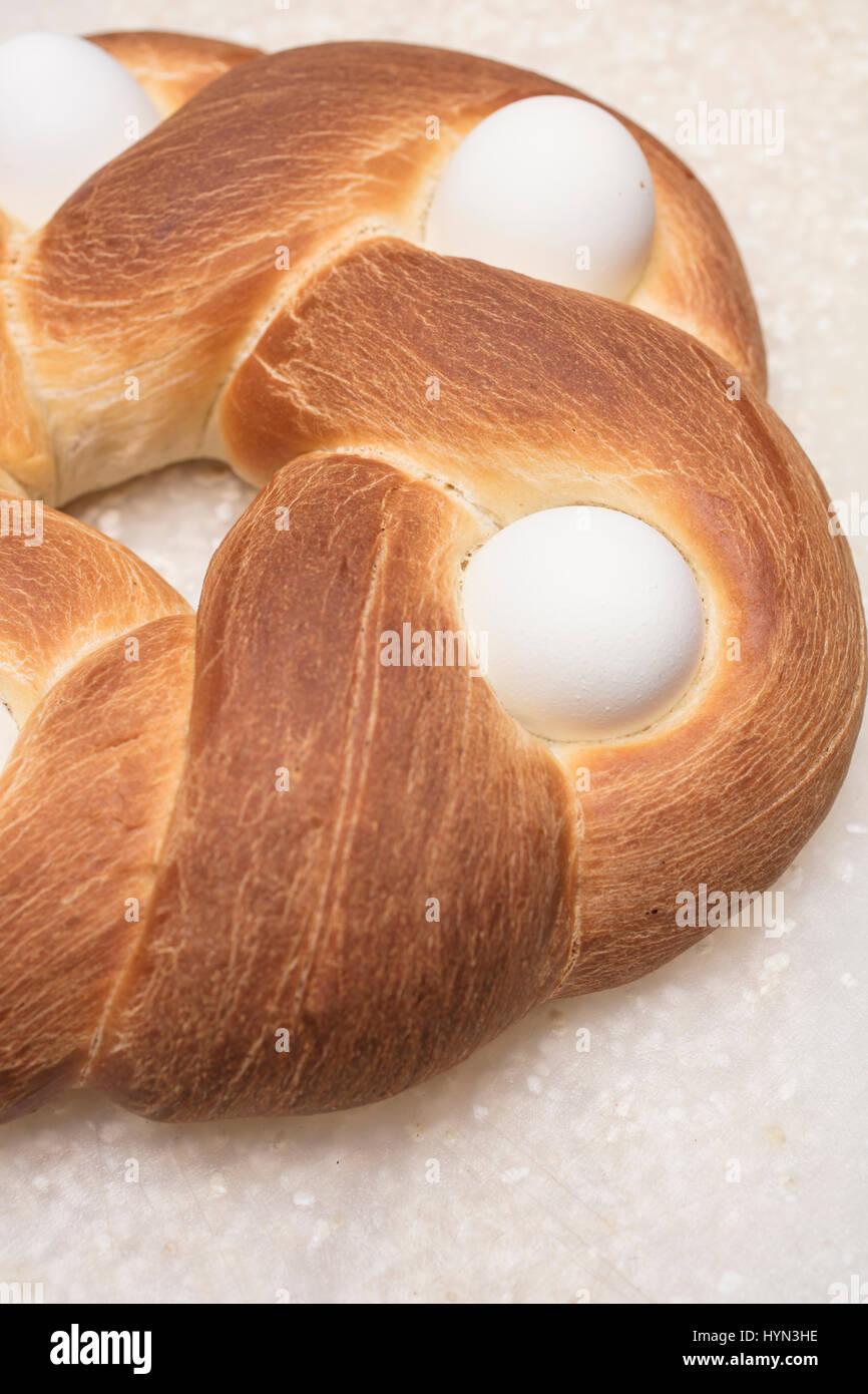 Geflochtene Osterbrot auf ein Schneidebrett mit gebackenen Eiern dekoriert Stockfoto