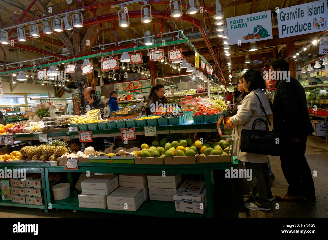Menschen, die Einkaufen bei einem Obst und Produkte Lieferanten innerhalb der Granville Island Public Market, Vancouver, Britisch-Kolumbien, Kanada Stockfoto