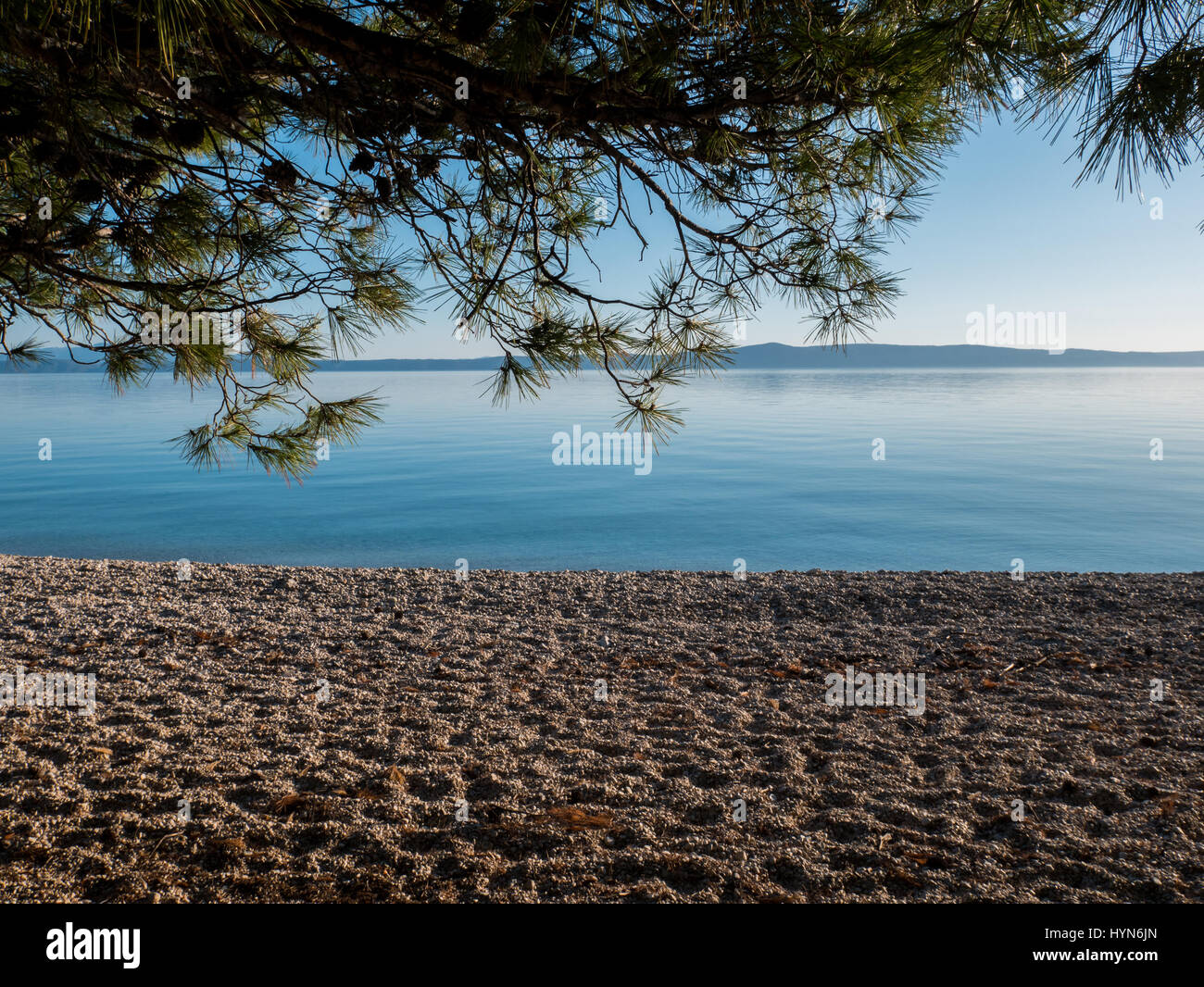 Landschaft-Szene von leeren Strand mit Kiefer und ruhige blaue Meer Stockfoto