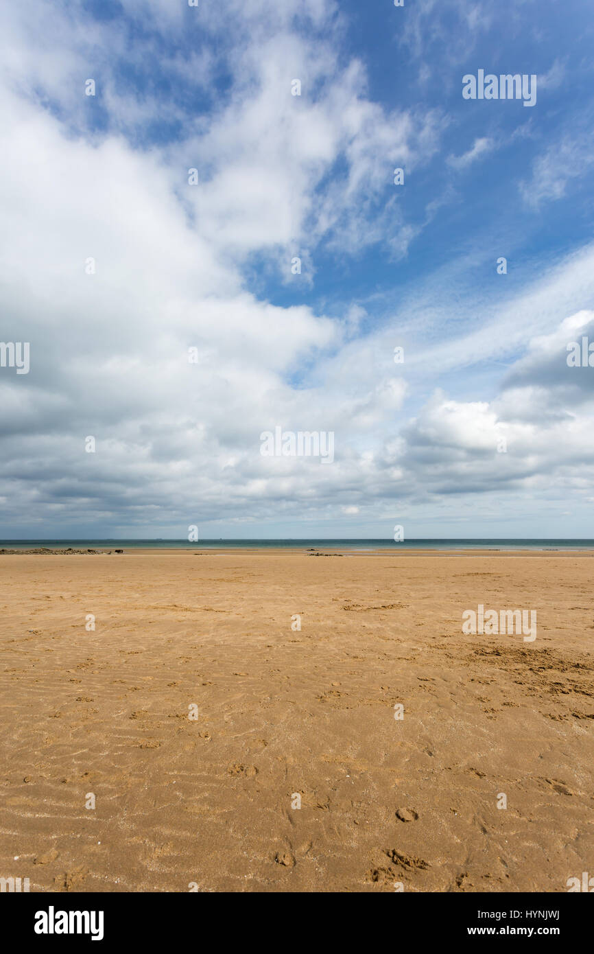 Sandstrand mit blauer Himmel bei Ebbe am Benllech in Anglesey, Nordwales Stockfoto