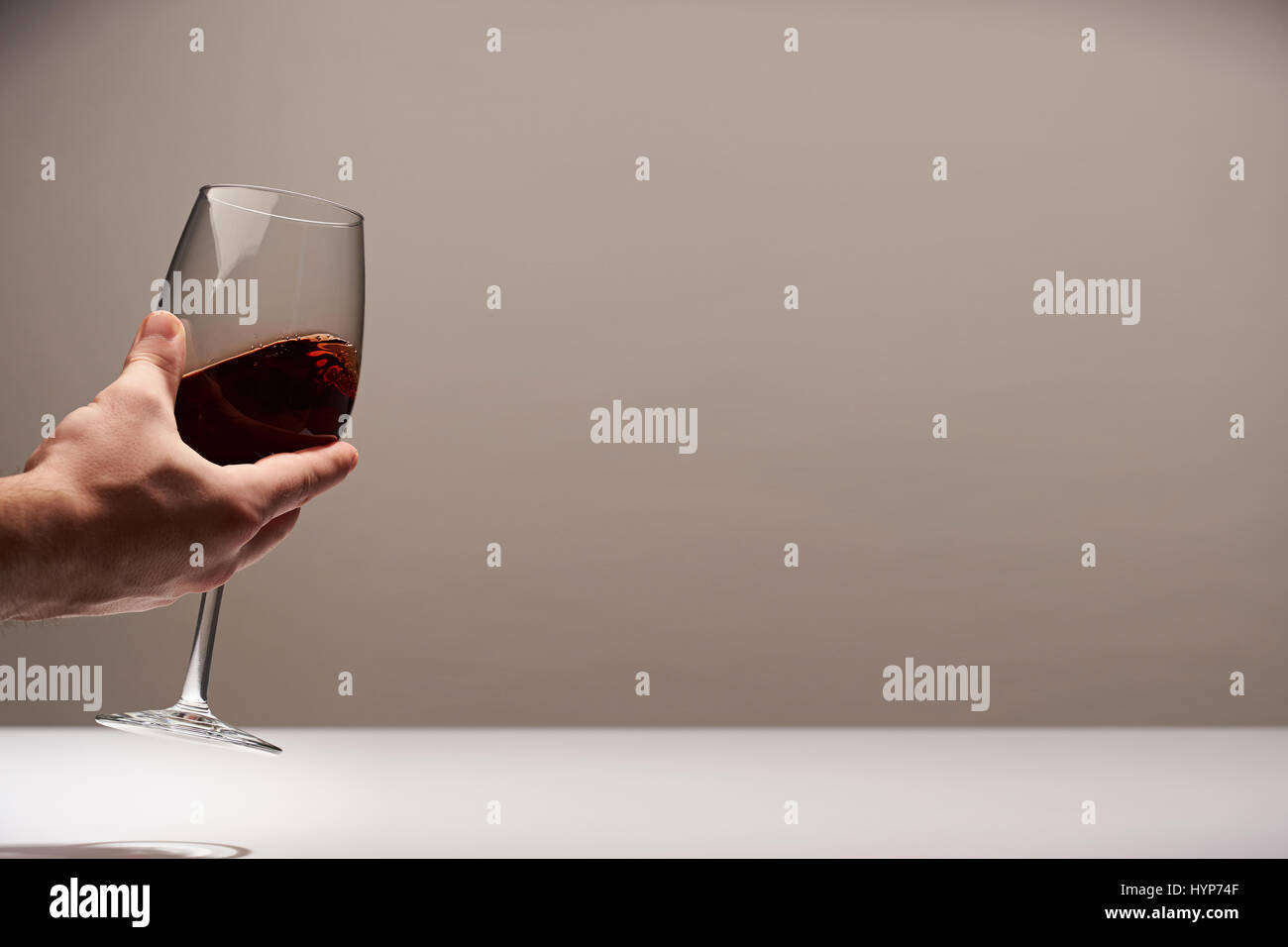 Eleganz rot Wein Hintergrund. Hand halten ein Rotweinglas Stockfoto Eleganz rot Wein Hintergrund. Hand halten ein Rotweinglas Stockfoto