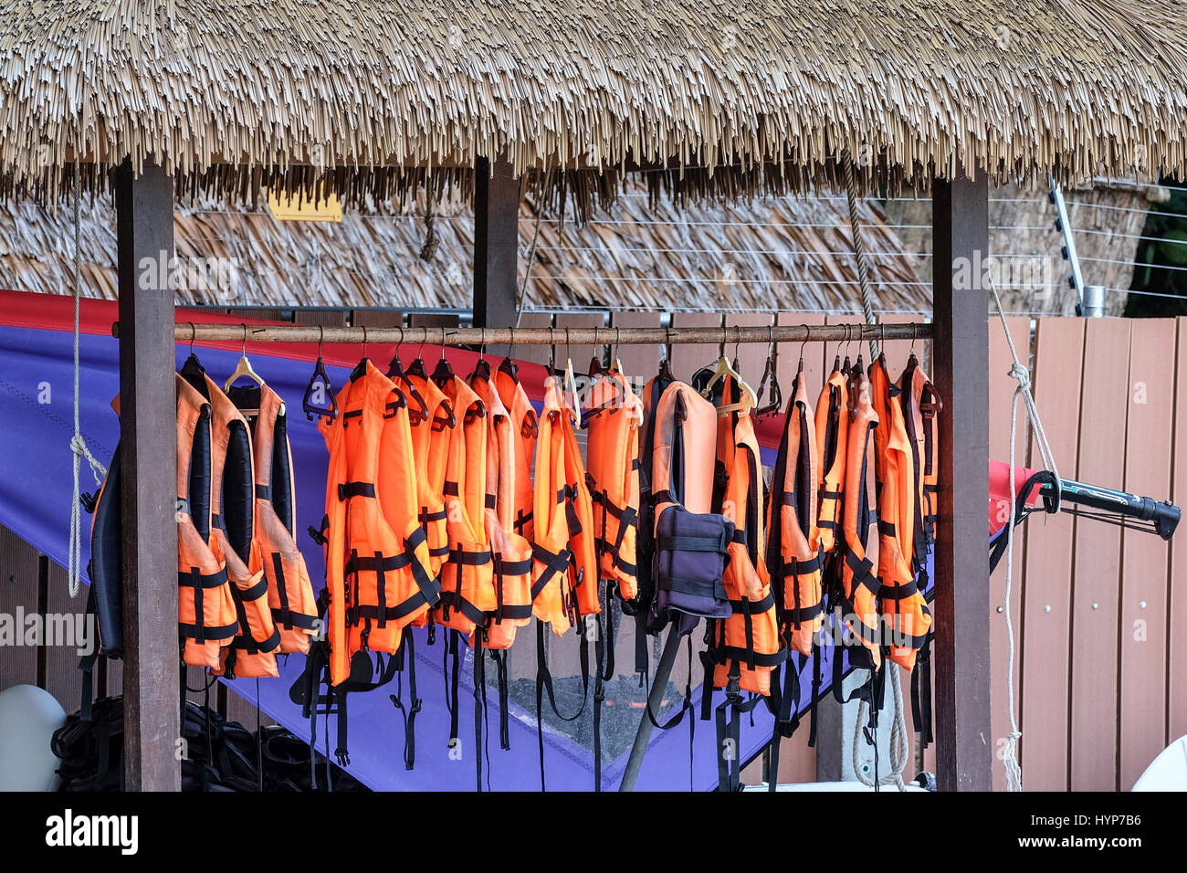 Farbe Orange Schwimmwesten, bedeckt hängt an der Wand der Boot station Stockfoto