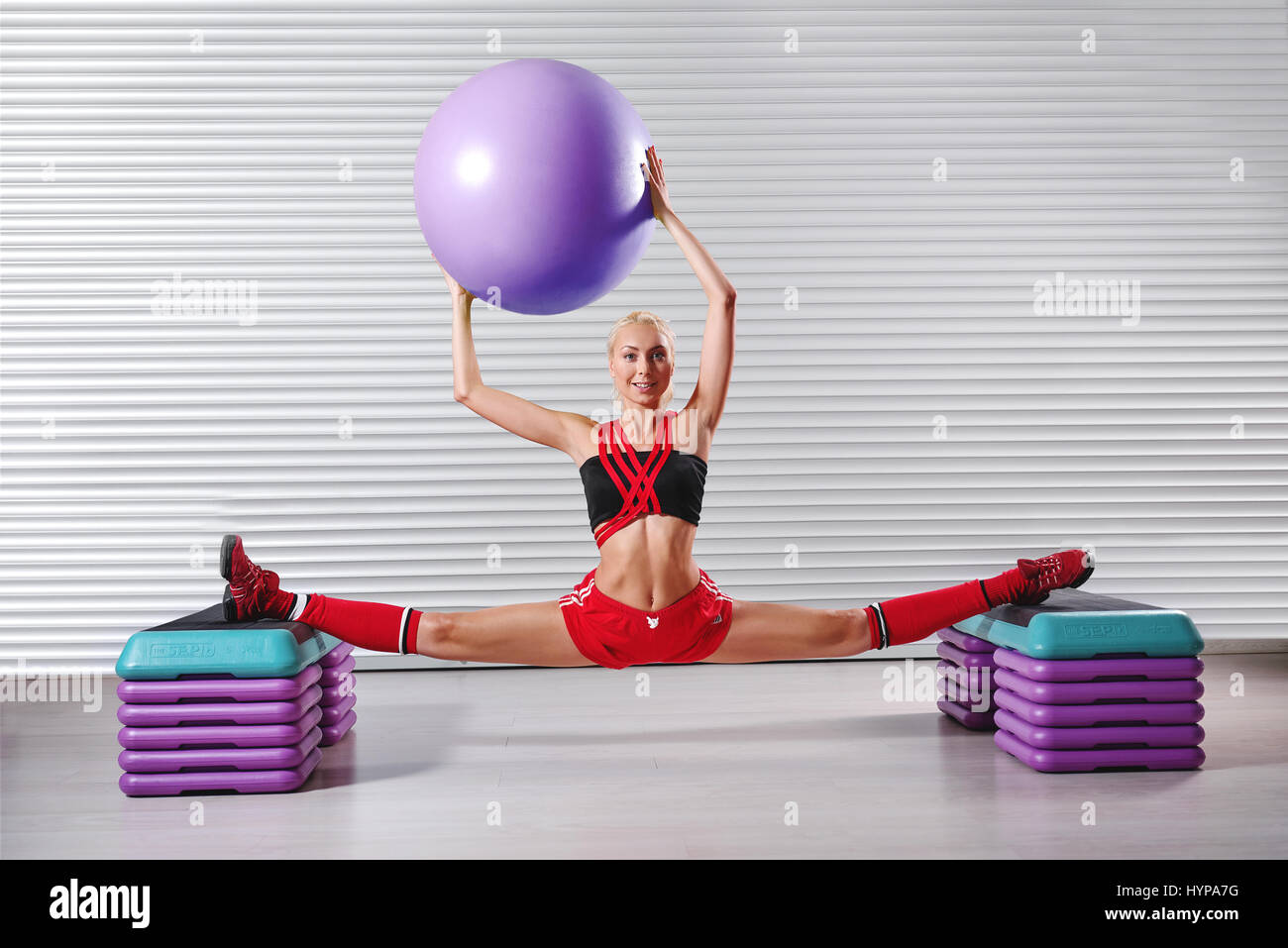 Schöne junge flexible Fitness Frau tun teilt, während ihr w Stockfoto