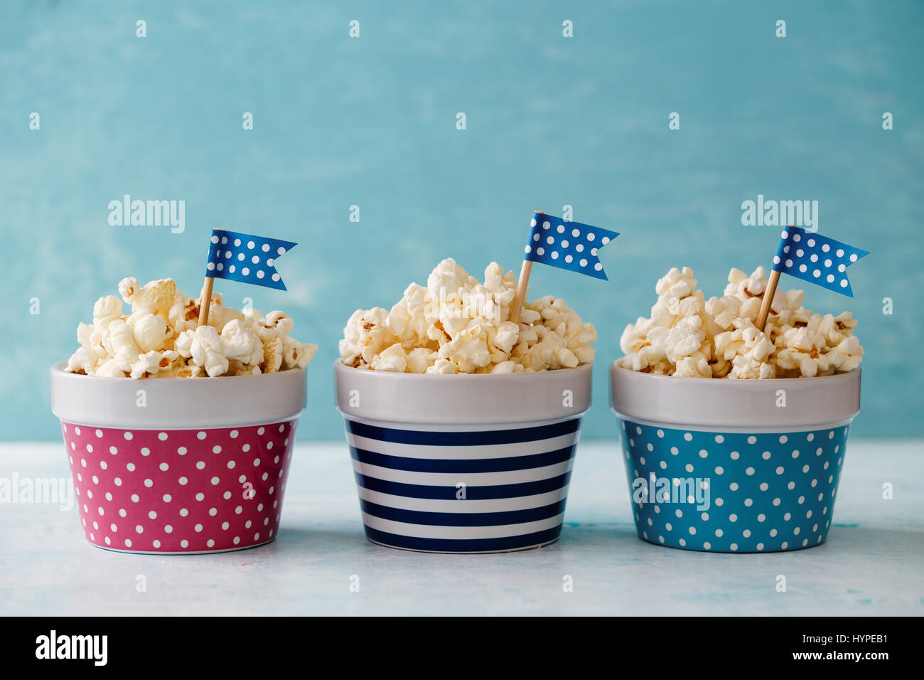 Hausgemachte Butter Popcorn serviert in bunten Schalen mit Partei Fahnen geschmückt. Popcorn in Streifen- und Schalen angeordnet. Stockfoto