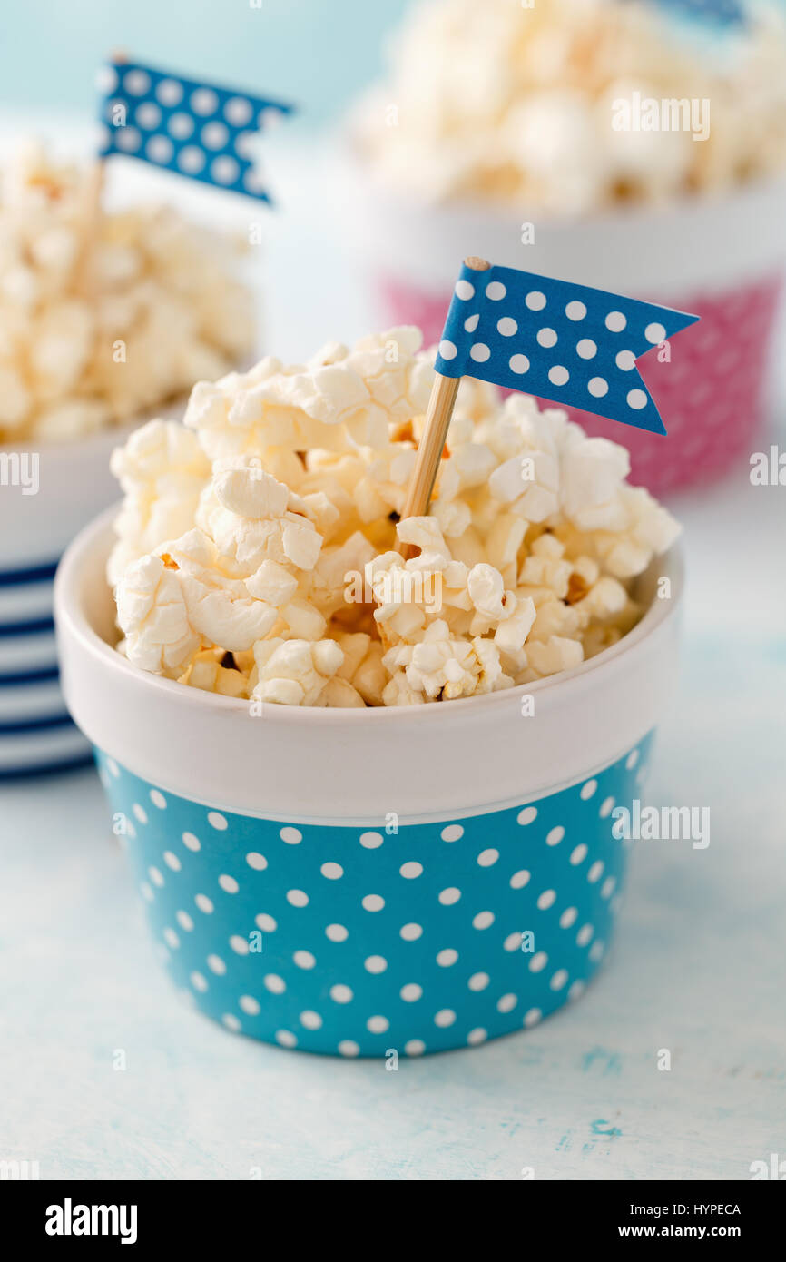 Hausgemachte Butter Popcorn serviert in bunten Schalen mit Partei Fahnen geschmückt. Popcorn in Streifen- und Schalen angeordnet. Stockfoto