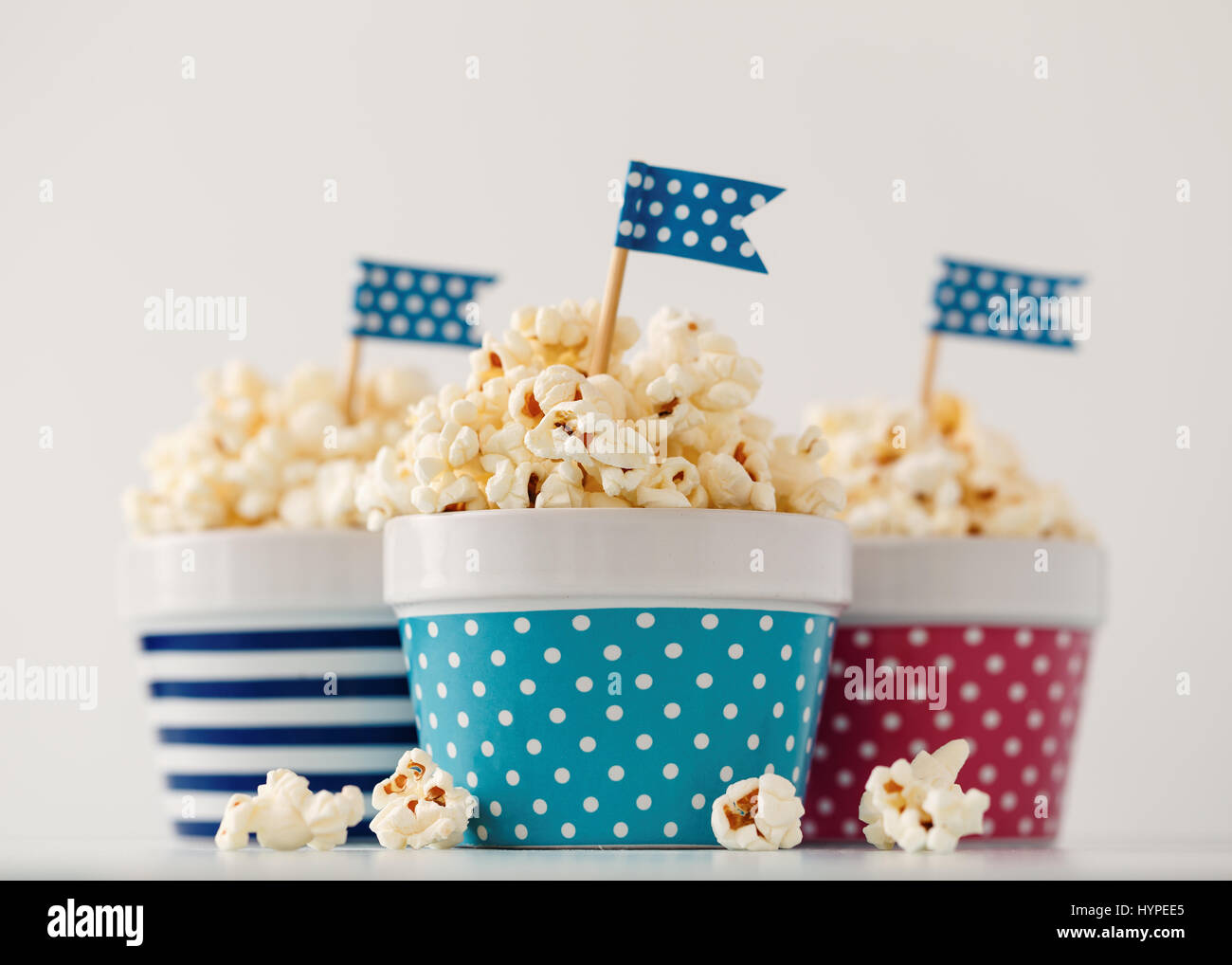 Hausgemachte Butter Popcorn serviert in bunten Schalen mit Partei Fahnen geschmückt. Popcorn in Streifen- und Schalen angeordnet. Stockfoto