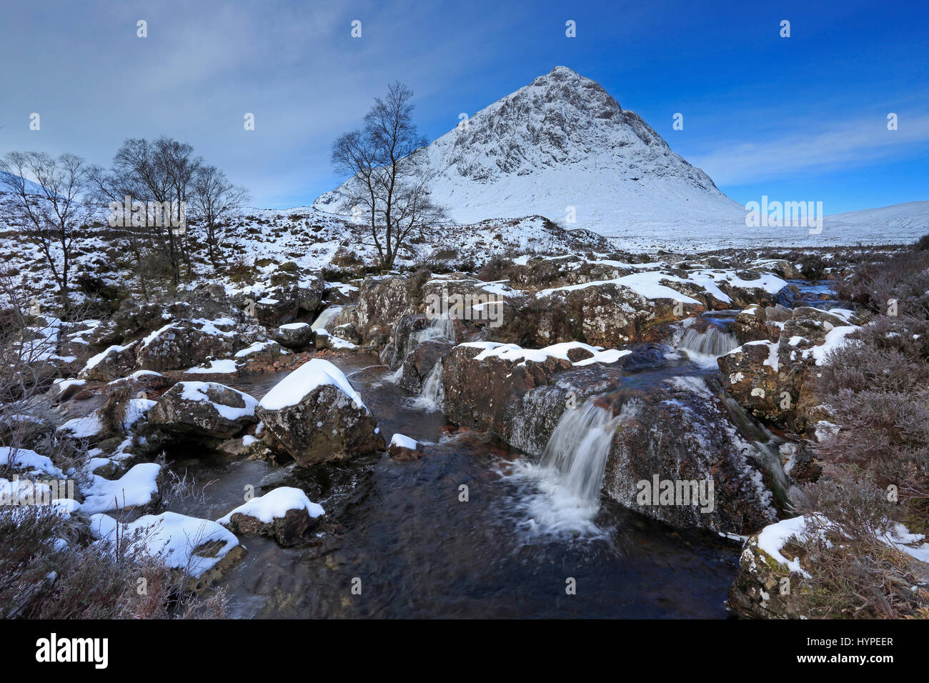 Wasserfall vor Schnee bedeckt Buchaille Etive Mor in Glencoe-Schottland Stockfoto