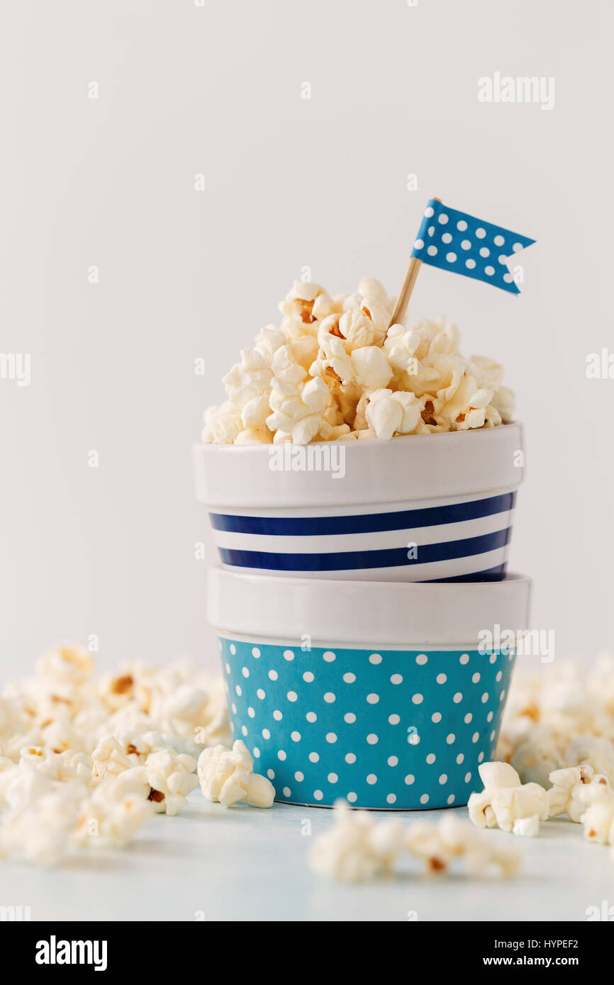 Hausgemachte Butter Popcorn serviert in bunten Schalen mit Partei Fahnen geschmückt. Popcorn in Streifen- und Schalen angeordnet. Stockfoto