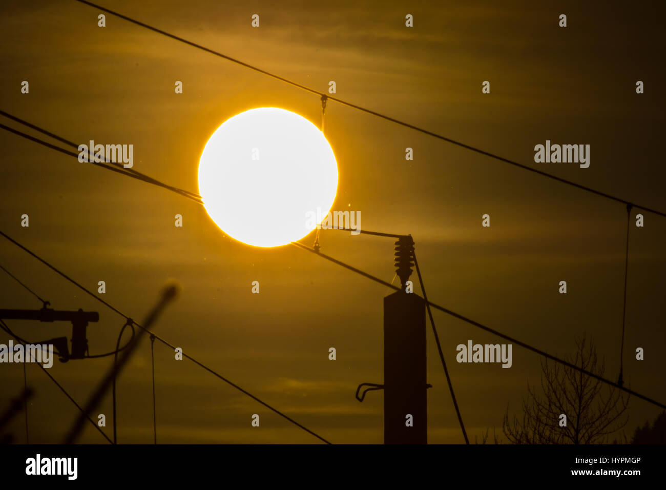 Eine Silhouette von Hochspannungsleitungen vor einem dramatischen und bunten Himmel bei Sonnenaufgang. Stockfoto