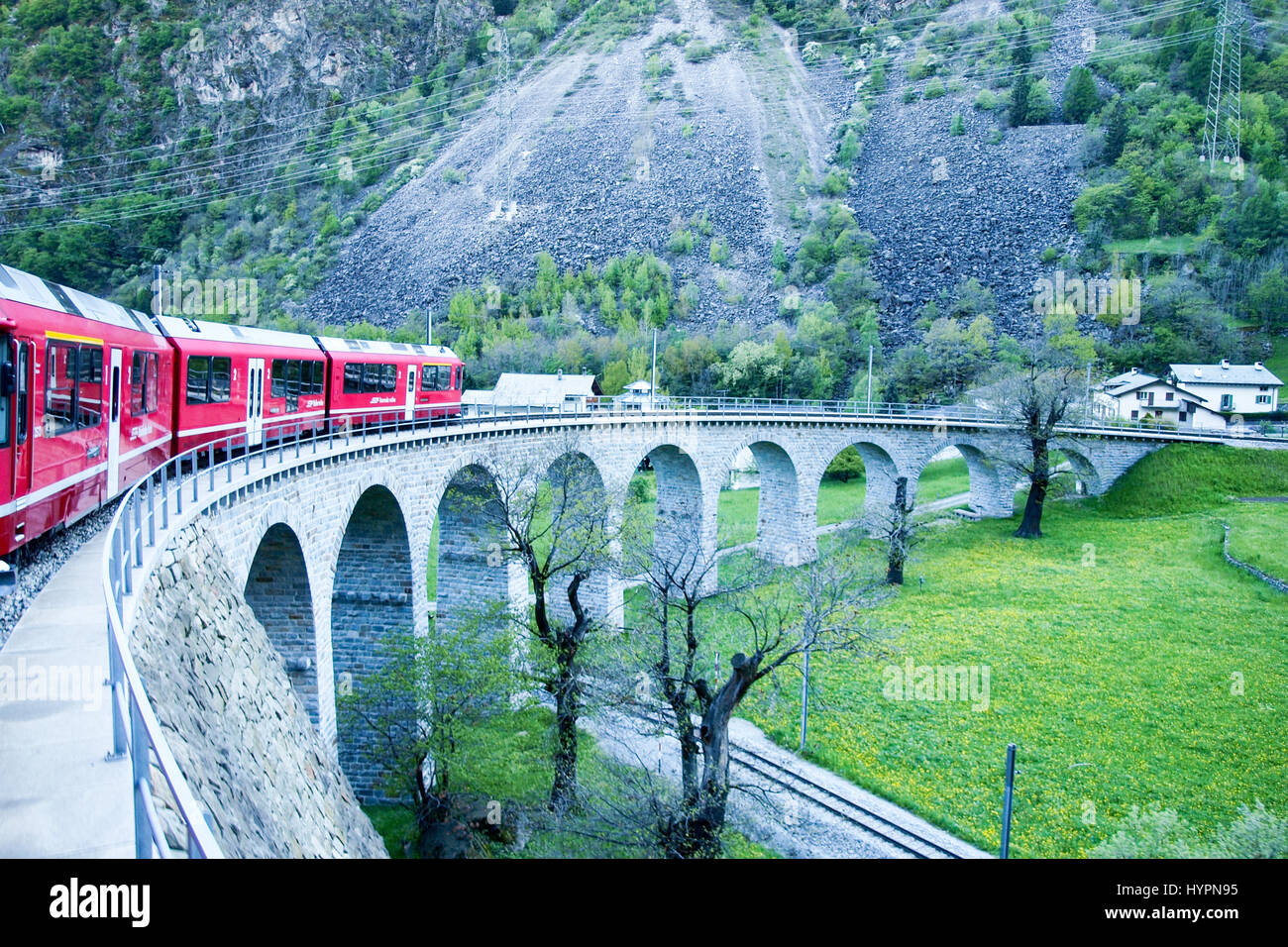 Brusio, Schweiz - 27. April 2016: Züge der Rhätischen Bahn auf der Durchreise entlang der Linie von Tirano nach St. Moritz. Stockfoto