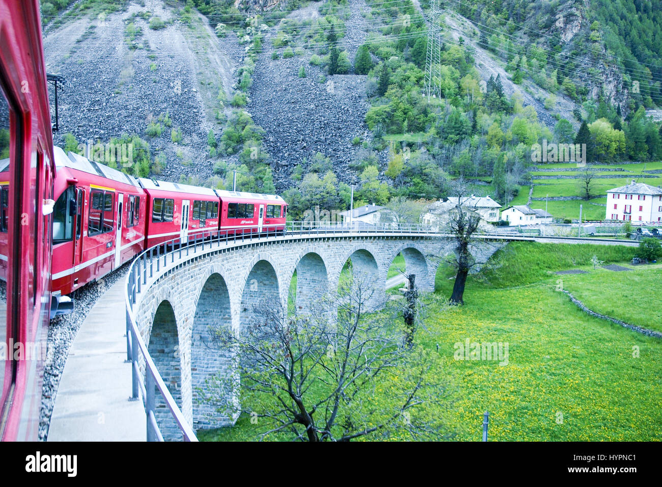 Brusio, Schweiz - 27. April 2016: Züge der Rhätischen Bahn auf der Durchreise entlang der Linie von Tirano nach St. Moritz. Stockfoto