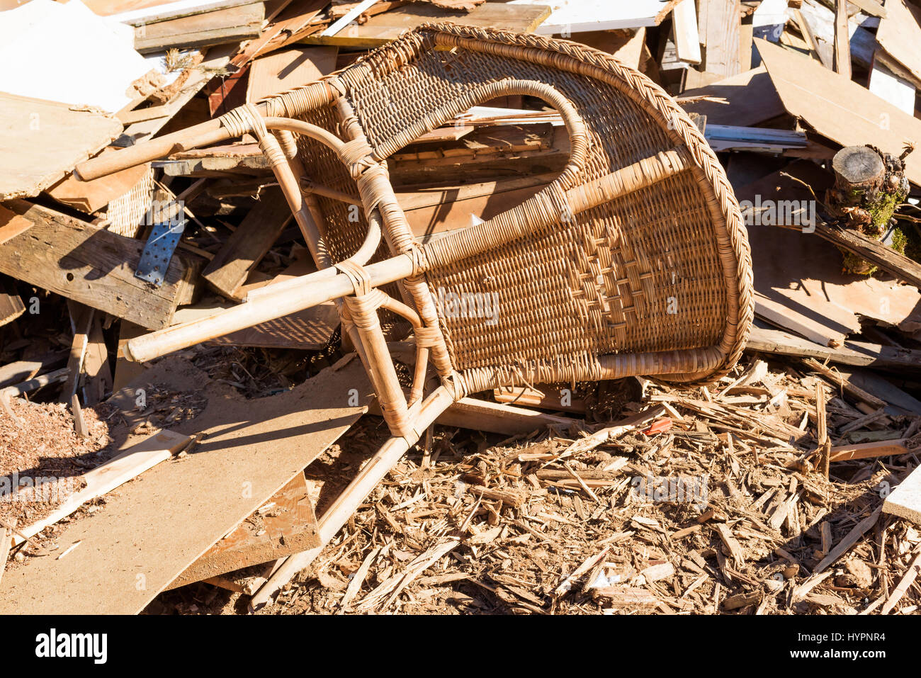 Papierkorb Rattan Stuhl in einen Trümmerhaufen sortiert aus Holz. Stockfoto