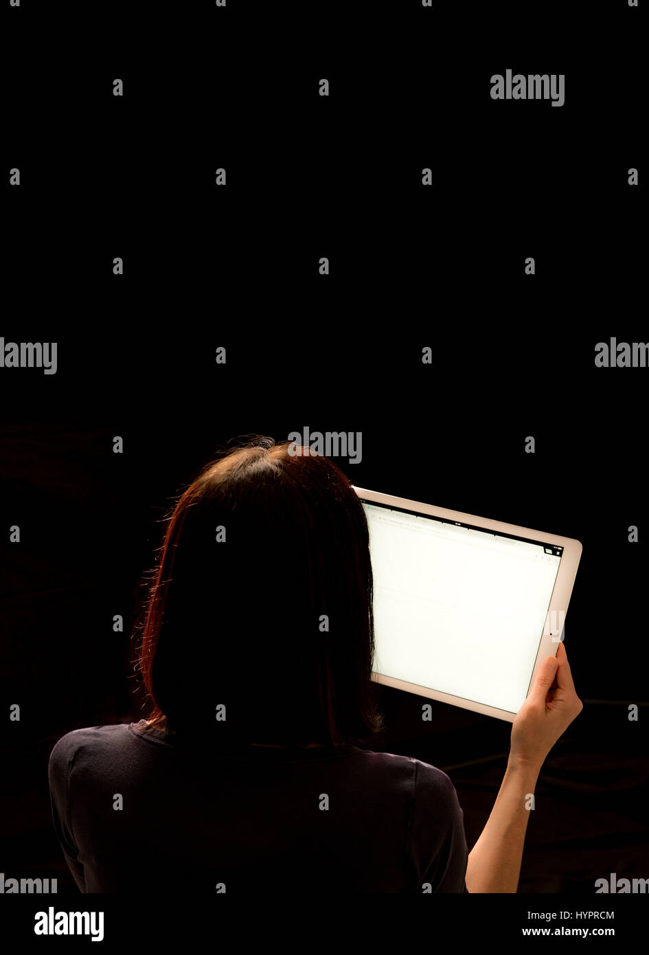 Blick auf das iPad Pro Frau hielt in der hand vor schwarzem Hintergrund Stockfoto