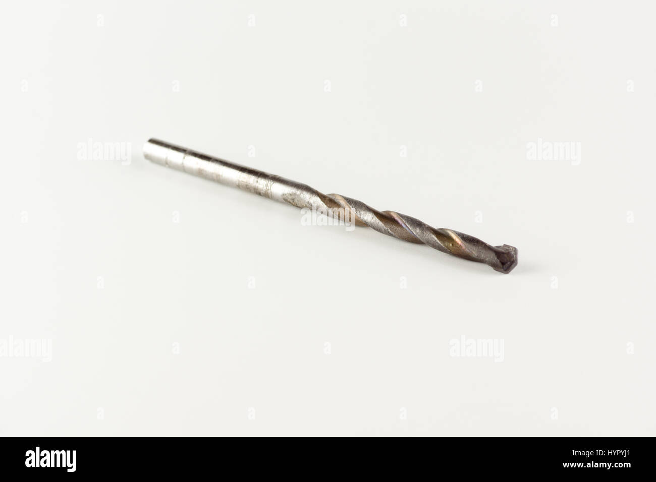 gebrauchte Beton Bohrer liegt auf einem weißen Hintergrund Stockfoto