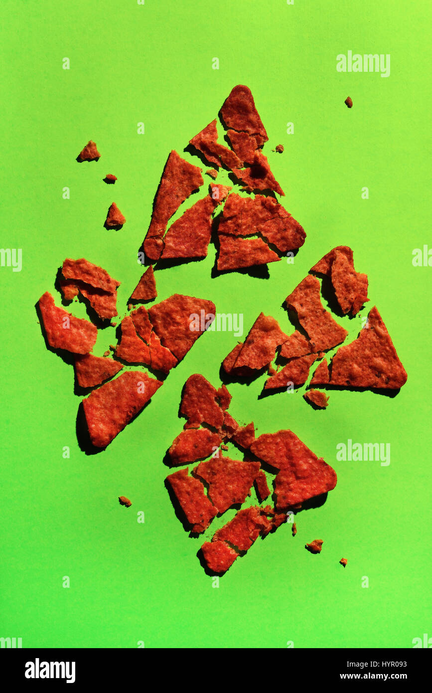 Flammenden heißen Doritos zerkleinert auf grünem Hintergrund Stockfoto