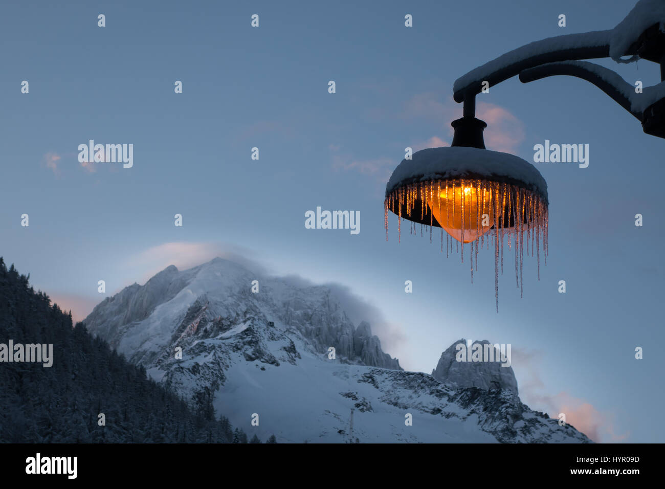 Schnee und Eiszapfen bedeckt Bernstein leichte Post vor Hintergrund der Wind fegt über den Berg Grat der Aiguille Verte und Les Drus Stockfoto