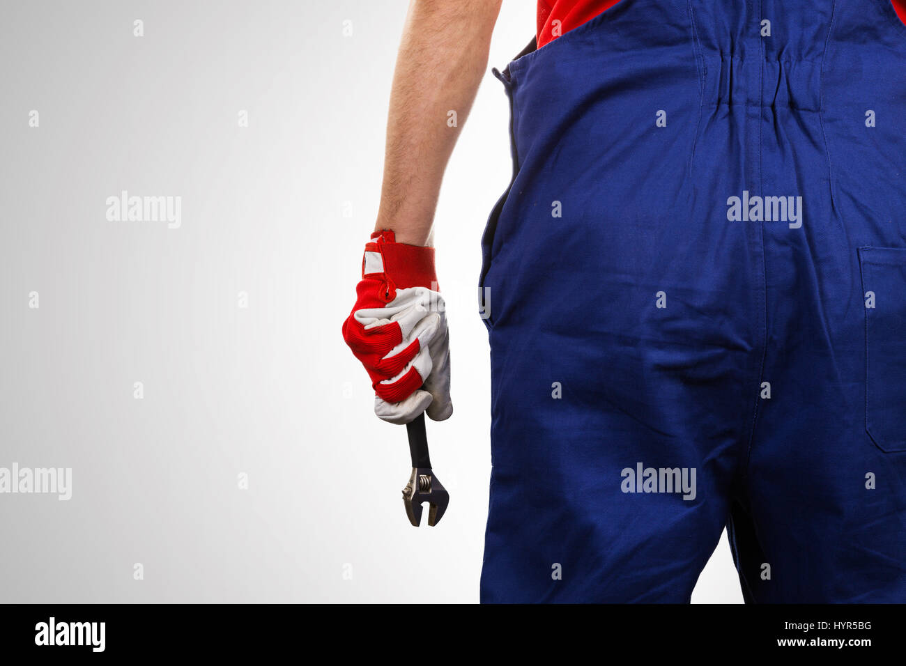 Handwerker mit Schraubenschlüssel in der Hand auf grauem Hintergrund mit Textfreiraum Stockfoto