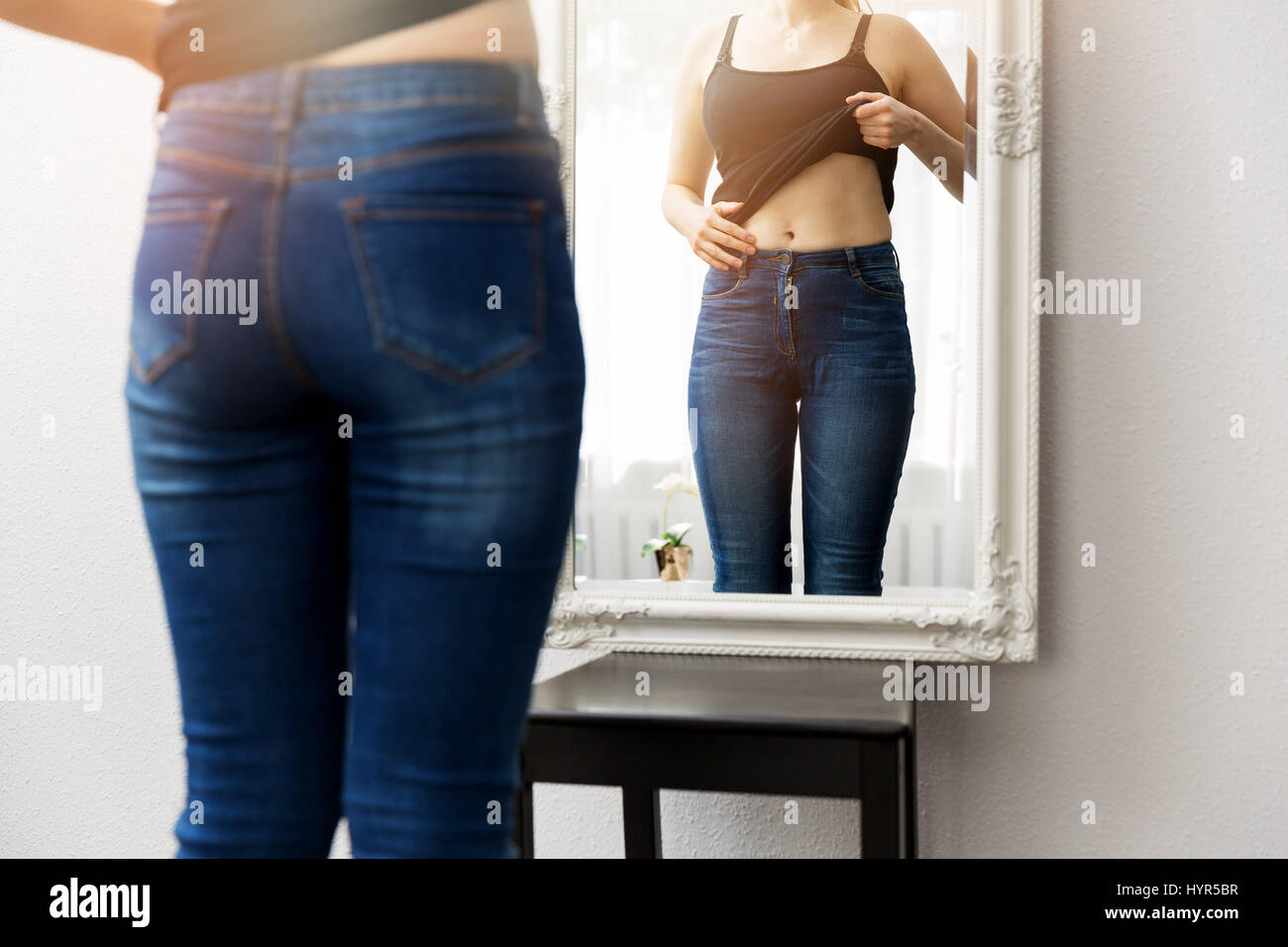 Überprüfen Sie ihren Körper vor Spiegel Frau Stockfoto