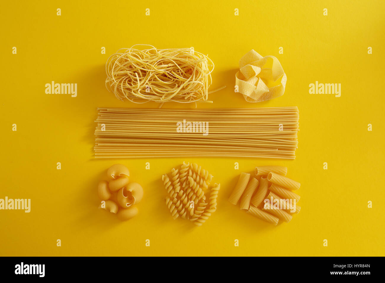 Verschiedene Arten von Nudeln auf gelbem Hintergrund. Verschiedene Formen von Nudeln. Stockfoto