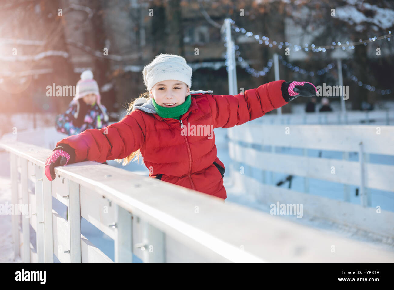 Zwei Mädchen auf der temporäre Eisbahn Schlittschuh laufen lernen Stockfoto