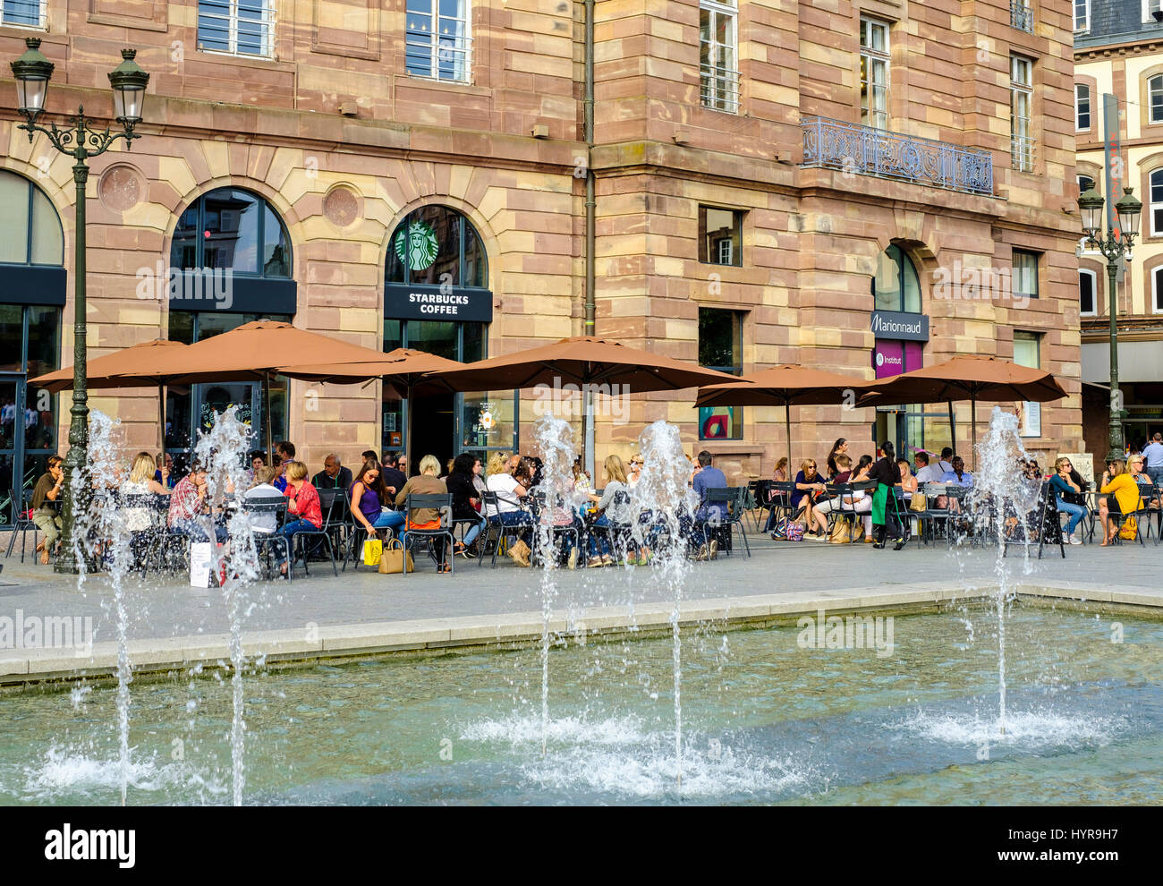 Starbucks Café Terrasse, Menschen, Aubette Gebäude, Brunnen Düsen, Place Kléber-Platz, Straßburg, Elsass, Frankreich Stockfoto