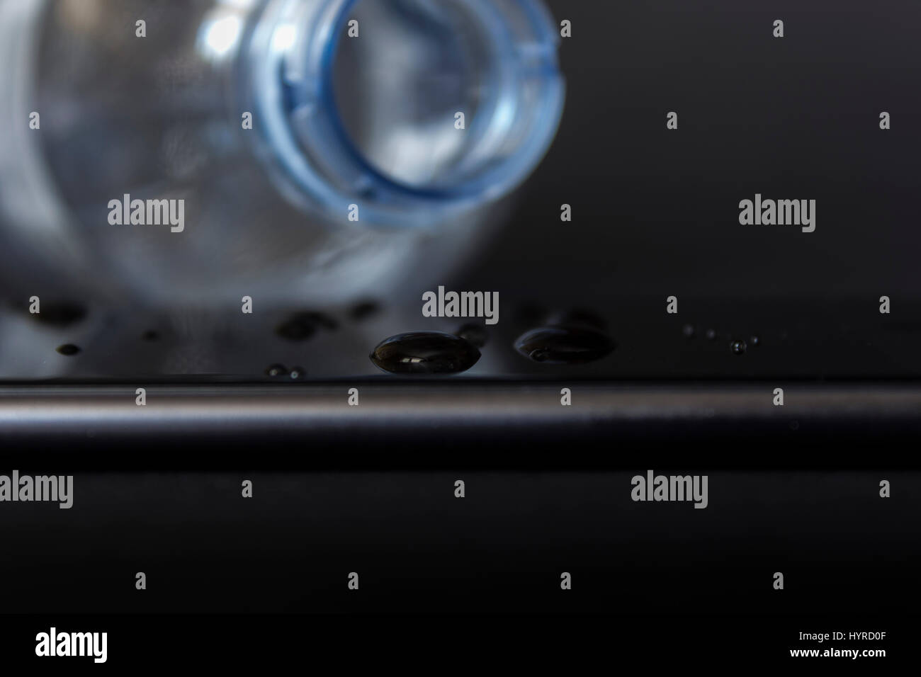 Wasser verschüttet aus einer Flasche auf einem smartphone Stockfoto