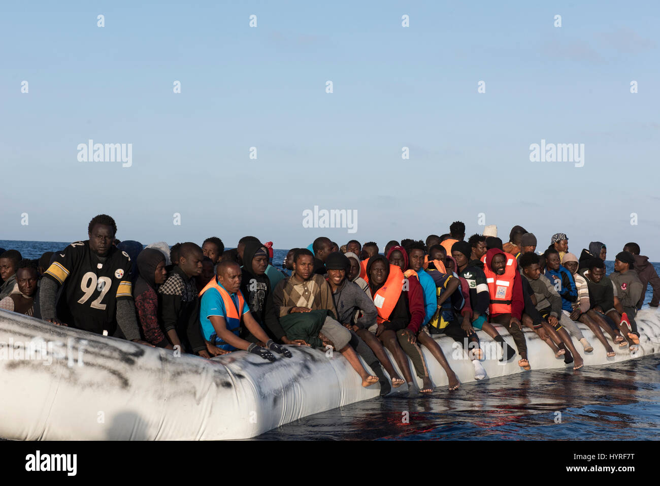 Etwa 150 Flüchtlingen/Migranten aus Afrika sitzen auf einer Rubberboat in schlechtem Zustand und möchten das Mittelmeer nach Europa zu gelangen. Stockfoto