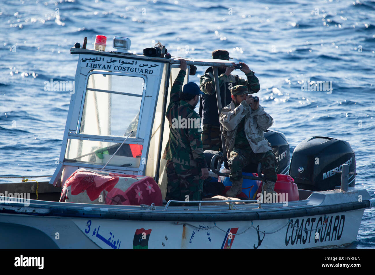 Ein kleines Boot mit 5 Personen, die sich selbst libyschen Küstenwache ein Rubberboat mit Migranten und beobachten und dokumentieren die SAR-Operation folgte Stockfoto