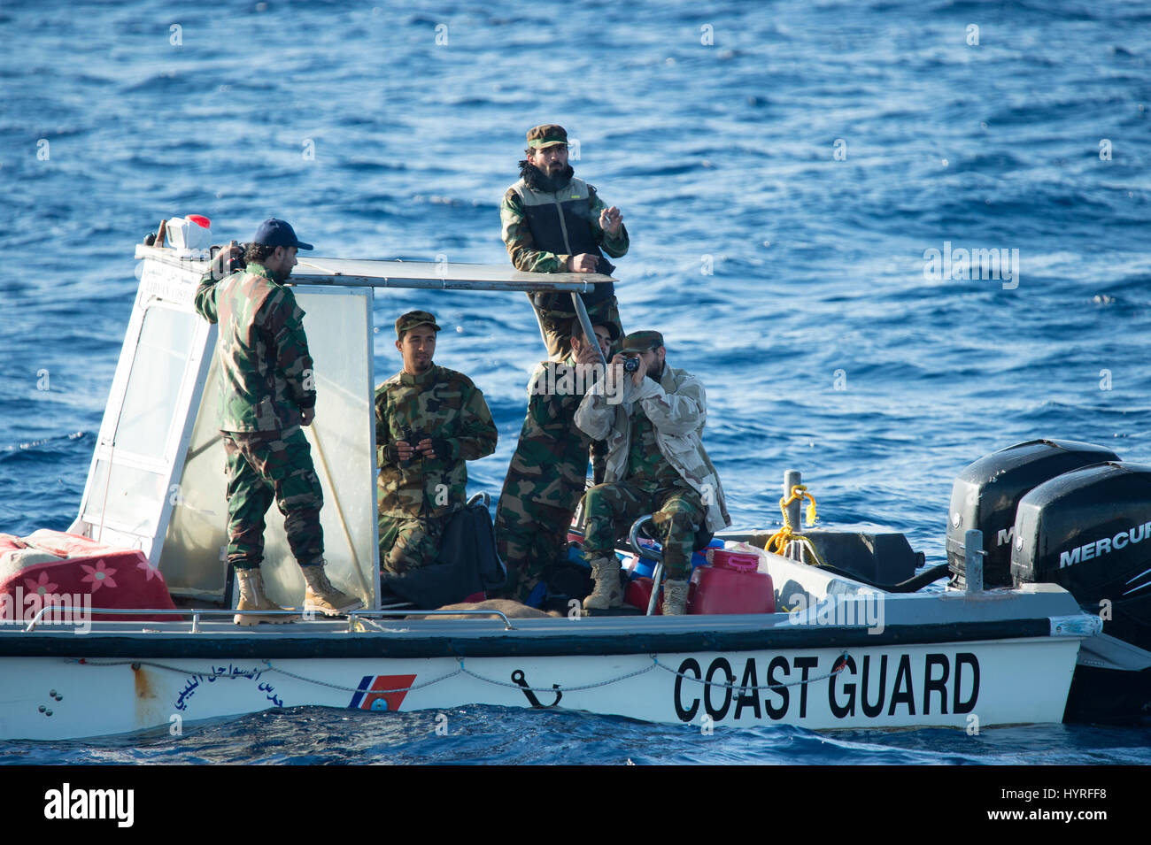 Ein kleines Boot mit 4 Personen, die sich selbst libyschen Küstenwache ein Rubberboat mit Migranten und beobachten und dokumentieren die SAR-Operation folgte Stockfoto