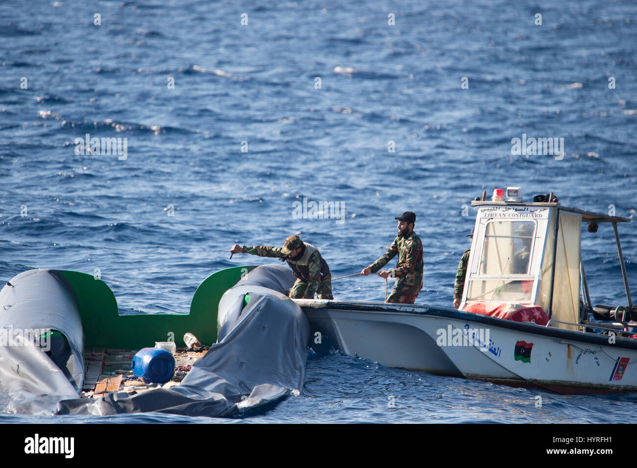 Ein kleines Boot mit 4 Personen, die sich selbst libyschen Küstenwache ein Rubberboat mit Migranten und beobachten und dokumentieren die SAR-Operation folgte Stockfoto