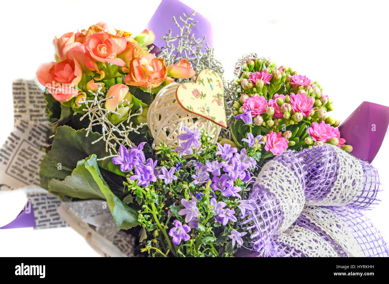 Blumenarrangement in Zeitungspapier mit wilden lila Blüten, rosa Calandiva Blumen, Kalanchoe, violette Bogen eingewickelt. Stockfoto