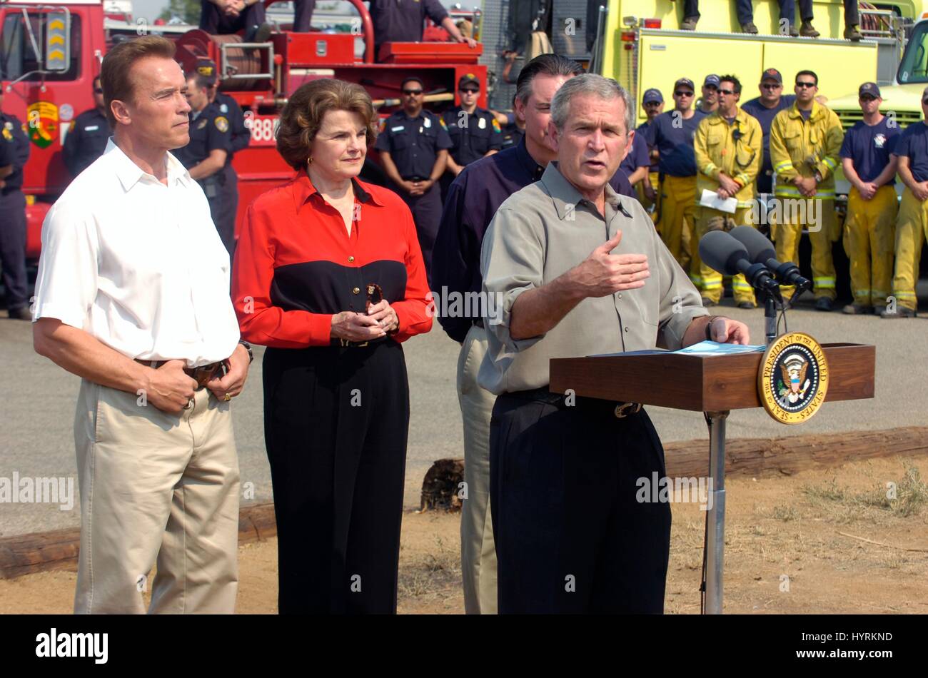 Kaliforniens Gouverneur Arnold Schwarzenegger und Kalifornien Senatorin Dianne Feinstein zusehen, wie US-Präsident George W. Bush während eines Besuchs ein Lauffeuer am Kit Carson Park 25. Oktober 2007 in Escondido, Kalifornien spricht. Stockfoto