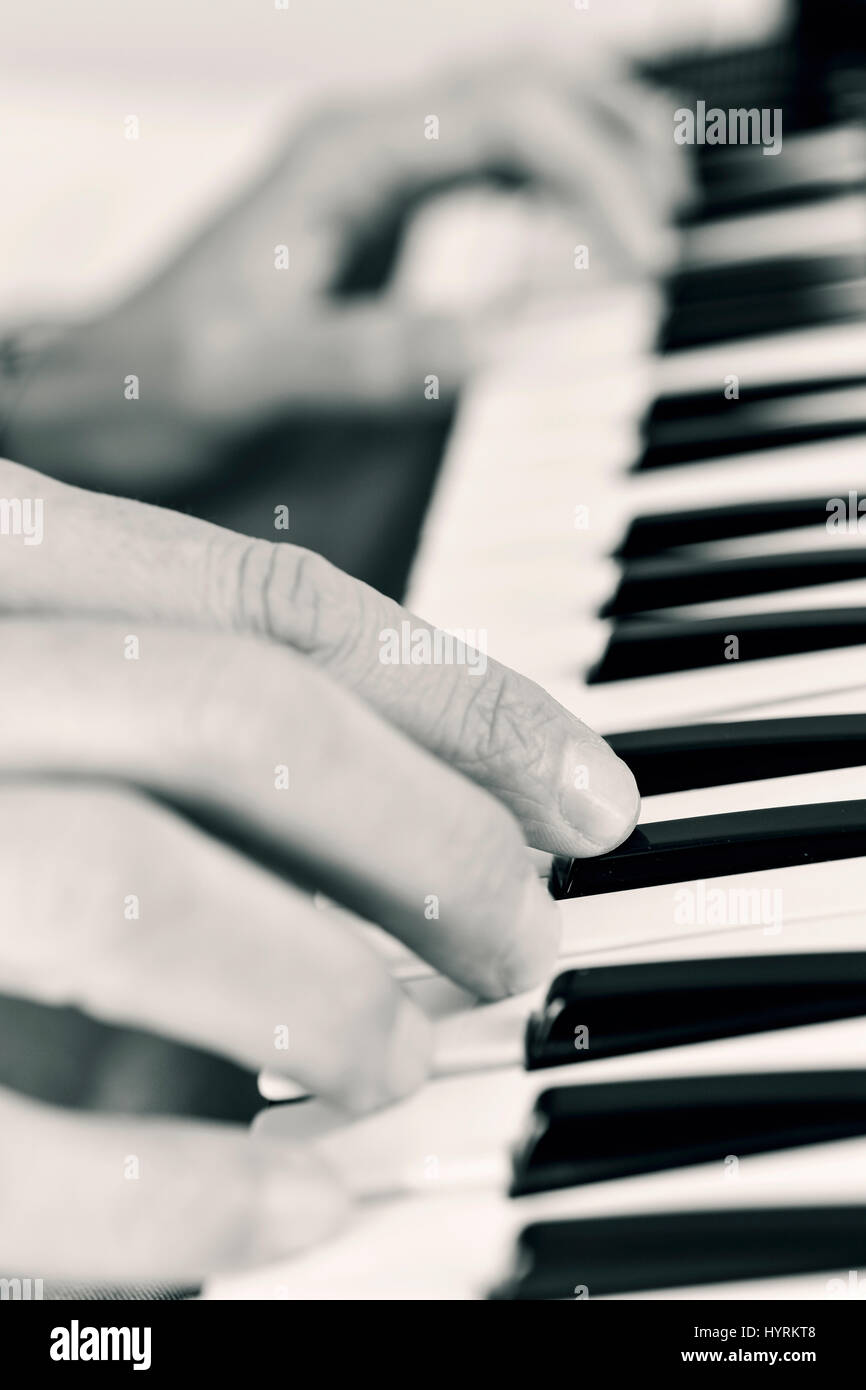 Closeup von einem kaukasischen Jüngling eine elektronische Tastatur in schwarz und weiß spielen Stockfoto
