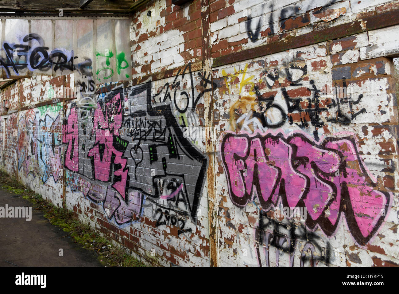 Eine Wand eines verlassenen Gebäudes mit lebendigen Straße Graffiti bedeckt. Stockfoto