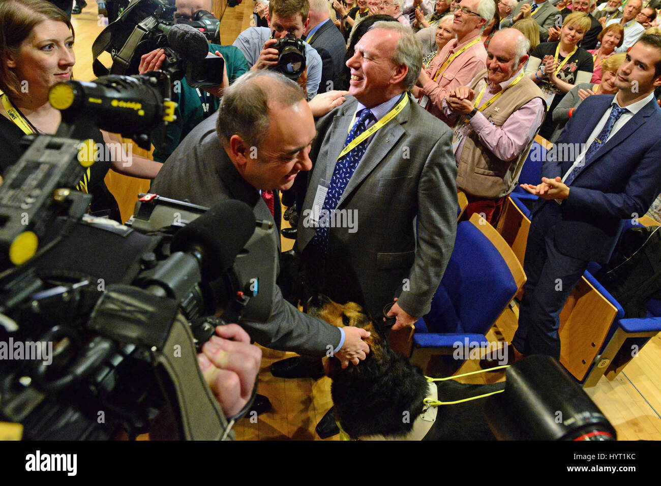 Alex Salmond umarmt Dennis Robertson MSP und seinen Blindenhund Herr Q nach Angabe seiner Abschiedsrede als SNP Führer der Partei Jahreskonferenz in Perth Stockfoto