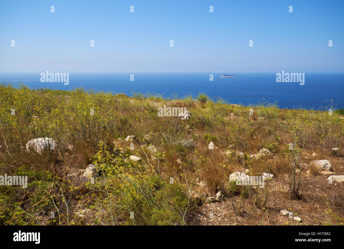 Die Ansicht der Qrendi Küste verbrannte Erde mit der Insel Filfla auf dem Hintergrund. Malta Stockfoto