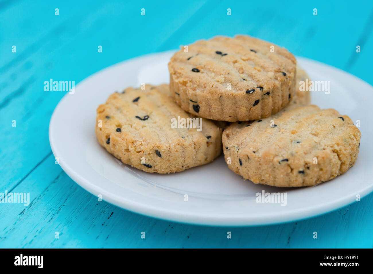 Seite Ansicht Keks mit Sesam auf Teller auf einem blauen Hintergrund Holz Stockfoto