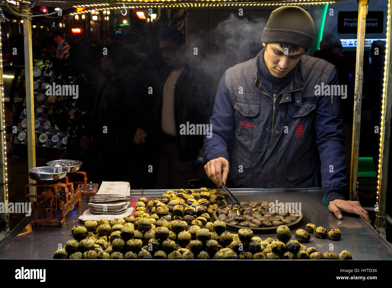 ISTANBUL, Türkei - 28. Dezember 2015: Bild von einem jungen Kastanien Verkäufer an einem kalten Winterabend auf Istiklal-Straße junge Kastanie Verkäufer auf Istikl Stockfoto